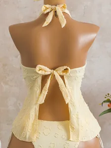 Detailed back view of cream floral textured tankini swimwear with halter and bow ties