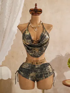 Detailansicht eines glänzenden goldfarbenen Bikinis mit Wasserfall-Ausschnitt und Hotpants.