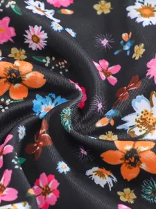 Detailed close-up view of vibrant floral print on premium black stretch bikini fabric