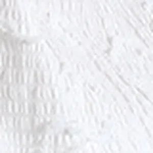 Macro view showing the intricate floral textured pattern on white tankini swimwear fabric.