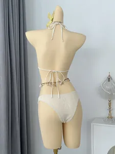 Gedetailleerd achteraanzicht van de witte gehaakte bikini met schelpen-tailleketting