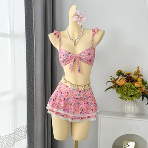 Two-piece pink floral bikini set with ruffles and lace trim skirt on mannequin