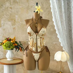 Elegant close-up of gold sequin floral embroidery on a cream ruffled vacation bikini set