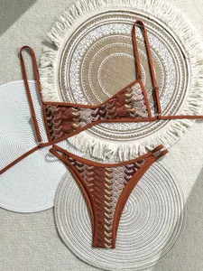 Detail eines Bohemian Häkelbikinis mit Retro-Wellenmuster, präsentiert auf gewebten Matten