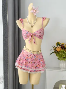 Detailed view of pink floral ruffled bikini set with lace-trimmed skirt on mannequin