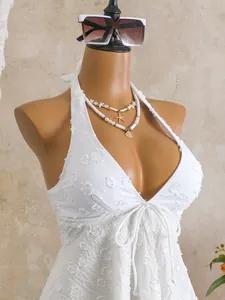 Detail view of white textured tankini top with floral pattern on a professional mannequin