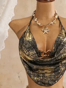 Nahaufnahme eines sexy schwarz-goldenen Bikini-Tops mit Wasserfall-Ausschnitt und Herz
