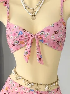 Detail view of pink floral bikini set with sea shell necklace and waist chain accessory