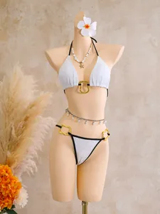 Detailed view of a white lace bikini set on a mannequin with summer accessories.