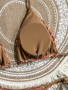Close-up of brown bikini top with colorful crochet trim and premium fabric detail