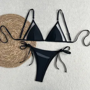 Detailansicht des schwarzen Mesh-Patchworks und der seitlichen Schnürung des Bikinis
