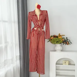 Detail view of stylish red and white striped beach vacation set with tied-waist long sleeve top
