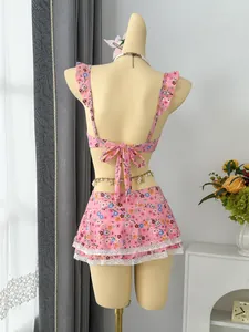 Back view of pink floral two-piece swimsuit with ruffle straps and lace-trimmed skirt