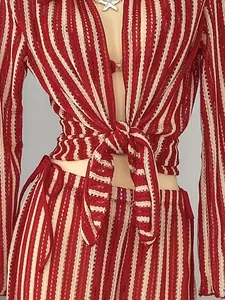 Close-up detail of a red and white striped knit swimwear set with a front-tie design