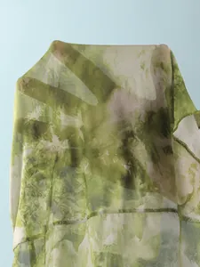 Détail du tissu en maille tie-dye vert montrant la texture transparente