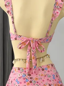 Back view of pink floral ruffle bikini with decorative bow tie and shell waist chain