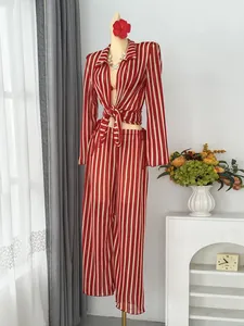 Detail view of stylish red and white striped beach vacation outfit with tie top and pants