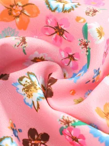 Macro detail of pink floral print swimwear fabric with vibrant flower patterns