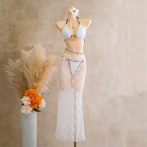 Detailed view of white lace three-piece bikini set with long mesh cover-up skirt