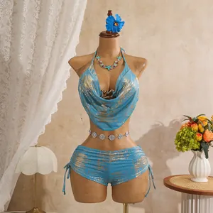 Sexueller blau-goldener Folienbikini mit Wasserfallausschnitt auf Resort-Hintergrund.