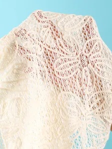 Macro view showing the intricate texture of cream crochet lace beach resort cover-up