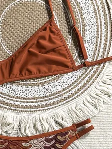 Makrodetail eines Bohème-Häkel-Bikini-Sets mit rostorangefarbenem Oberteil und Muster