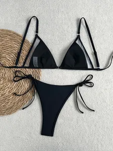 Detailansicht eines schwarzen Bikinis mit Mesh-Einsätzen und seitlichen Bindebändern