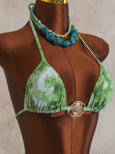Détail d'un haut de bikini licou vert tie-dye avec un anneau central métallique
