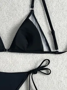 Detailansicht des schwarzen Bikini-Oberteils mit Netzeinsatz und Seitenschnürung.