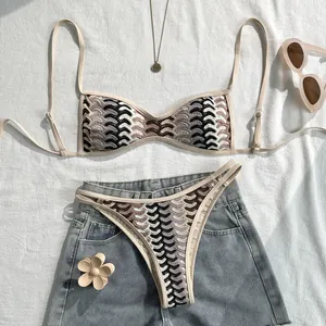 Detailaufnahme eines Bohème-Häkel-Bikini-Sets mit Retrowellenmuster auf weißem Stoff