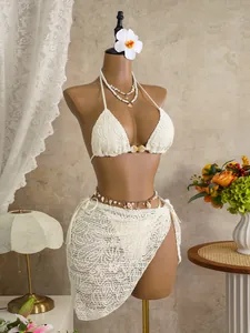 Detail of a white lace three-piece bikini set with matching sarong on a mannequin.