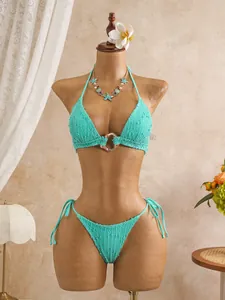 Detailed view of turquoise smocked halter bikini set with chic metallic ring design