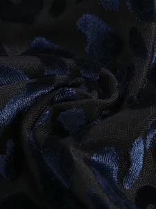 Detailed macro view of dark blue velvet leopard print fabric with black mesh texture
