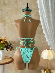 Detailed back view of a sexy mint green sequined floral bikini swimsuit on a mannequin