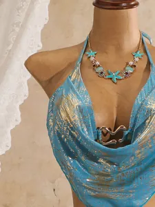 Detailansicht eines blauen Bikini-Oberteils mit Goldfolie und herzförmiger Schnalle