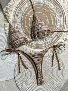 Detailed view of bohemian striped crochet bikini top and bottom on woven mats