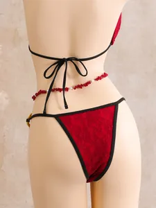 Back view of a sexy red lace 3-piece bikini set with a decorative red stone waist chain