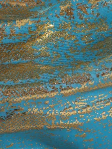 Detailansicht von blauem Bikini-Stoff mit einer glänzenden Goldfolien-Struktur
