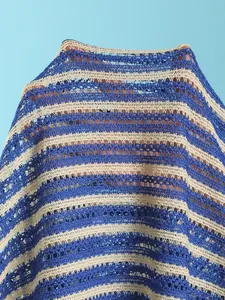 Detailed macro view of blue and beige horizontal striped crochet mesh beachwear fabric