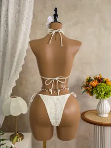 Detail view of white lace bikini bottom with a decorative shell and star waist chain