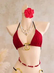Detailed view of a sexy red lace bikini featuring a golden ring and a red waist chain.