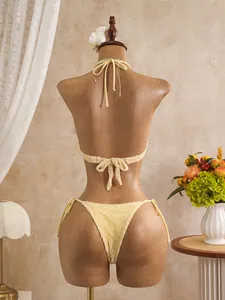 Detailed back view of a textured crochet bikini set in light yellow on a mannequin