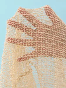 Macro view of cream-colored mesh fabric with sequins from a three-piece bikini set