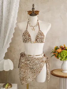 Elegant brown and white crochet 3-piece bikini set with wrap skirt on a mannequin