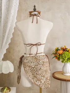 Detailed back view of brown bikini with floral lace sarong on mannequin for beachwear