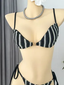 Detailansicht eines schwarz-weiß gestreiften Bikini-Oberteils mit goldenem Seestern-Akzent