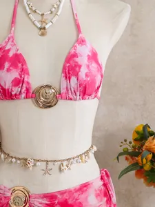 Détail en gros plan de l'ensemble bikini rose tie-dye avec des bijoux coquillages