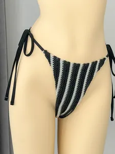 Detailansicht eines schwarz-weiß gestreiften Bikini-Unterteils mit Bändern an den Seiten.