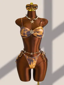 Detailweergave van een bruine tie-dye bikini in Maillard-stijl met strandaccessoires.