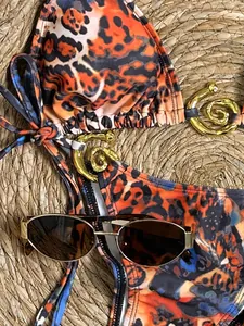 Vue détaillée d'un bikini imprimé léopard avec anneaux dorés et lunettes de soleil